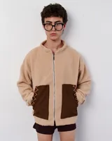 Chaqueta beige simil corderito con cierre frontal, cuello alto y bolsillos de pana marrón con bordados zig zag en hilo rojo y blanco.