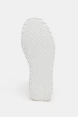 Zapatilla deportiva blanca, estilo sneaker, con capellada de cuero sintético y detalles de pespuntes en contraste de texturas. Presenta una suela plataforma gruesa con relieve dentado en la parte inferior.
