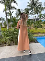 Vestido largo negro con panel lateral blanco, escote en V en la espalda y corte holgado.