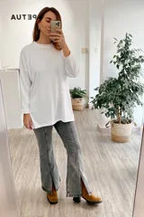 Pantalón jean gris de tiro medio alto, corte wide leg con tajo frontal.