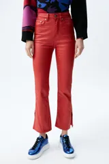 Pantalón jean plateado de tiro medio/alto con silueta levemente acampanada desde la rodilla y aberturas en los tobillos.