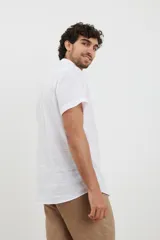 Camisa azul de manga corta, con cuello abotonado y bolsillo en el pecho.