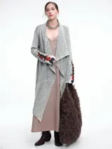 Saco tipo cárdigan largo de tejido térmico con efecto lavado, diseño de solapas amplias con detalle de encaje y mangas decoradas con bordados florales coloridos.