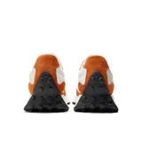 Championes New Balance 327 color naranja y blanco, con suela de goma negra.