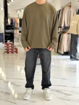 Buzo oversize marrón de manga larga, confeccionado en tela texturada con líneas verticales, cuello redondo y calce holgado.