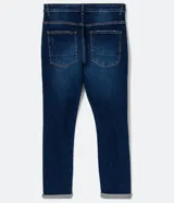 Pantalón de jean skinny azul oscuro con roturas en las rodillas y ruedo doblado.
