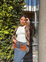 Falda midi de denim con elastano, corte recto y tajo frontal. Presenta bolsillos delanteros de cuero en color tostado y diseño clásico.