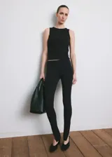 Top de canalé negro, confeccionado en mezcla de algodón, con cuello redondo y diseño sin mangas de corte entallado.