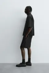 Bermuda de corte relajado color marrón con finas rayas verticales negras. Presenta cintura elástica ajustable con cordón y bolsillos laterales y trasero.