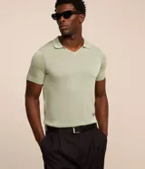 Remera polo de punto color verde menta, con cuello en V y mangas cortas.