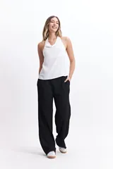 Pantalón de vestir de tiro alto, color crema, con textura crepe arrugada y pierna ancha y fluida. Presenta cintura elástica.