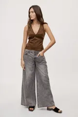 Jean de silueta wide leg, color gris con efecto acid wash, tiro medio y pierna amplia de caída recta. Cuenta con diseño clásico de cinco bolsillos, pasacintos y cierre frontal con botón y cierre.