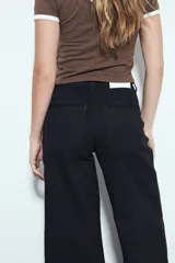 Pantalón de pierna amplia color beige, con silueta relajada y calce cómodo, confeccionado en denim con leve elasticidad. Presenta costuras a contraste.