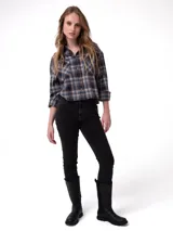 Camisa de corte cropped y diseño holgado, confeccionada en tela de franela con estampado a cuadros en tonos negro, azul y naranja. Presenta cuello camisero, cierre frontal con botones metálicos, mangas largas con puños abotonados y bolsillos frontales en el pecho.