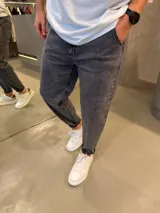 Jean de corte slouchy en color gris con efecto acid wash, con bolsillos laterales y traseros, y botamangas con dobladillo.