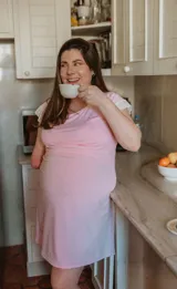 Camisón maternal corto color rosa con mangas cortas con puntilla blanca.