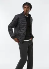 Campera puffer azul marino, con diseño acolchado de líneas horizontales, cuello alto y cierre frontal completo.