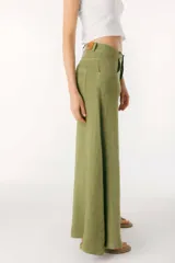 Pantalón blanco de lino, corte palazzo, con bolsillos laterales y cierre frontal con botón.