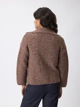 Cardigan de punto jaspeado en tonos marrones, con cuello solapa, cierre frontal de botones y mangas largas con diseño holgado.