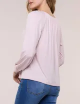 Blusa de modal y elastano color blanco, de silueta holgada, escote redondo amplio con elástico interno fruncido y mangas largas fluidas con puños ajustados.