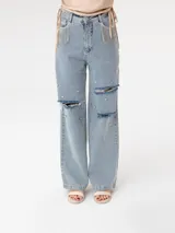 Pantalón de jean celeste de corte ancho, con roturas en las rodillas y apliques de strass.