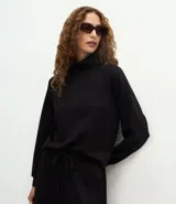 Buzo de corte regular confeccionado en mezcla de poliéster, viscosa y elastano. Presenta cuello alto estructurado, mangas largas con puños ajustados y diseño liso.