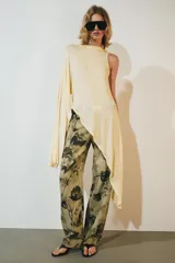 Top asimétrico de mezcla de lyocell en color amarillo claro, con cuello redondo y diseño fluido de corte irregular con una manga larga y un lateral drapeado.