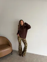 Pantalón tipo oxford de tiro alto, con estampado abstracto en tonos tierra, negro y crema. Presenta un corte ajustado en la parte superior y acampanado desde la rodilla hacia abajo.