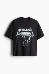 Remera negra de algodón con corte oversized, hombros caídos y estampado frontal de la banda Metallica con el texto "DAMAGE INC. 1986".