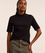 Remera negra de algodón, corte amplio, cuello alto en punto roma y mangas cortas.