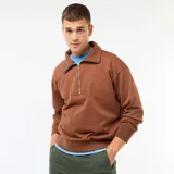 Buzo de algodón color marrón con cuello chimenea acanalado y cierre frontal parcial plateado. Presenta puños y cintura acanalados.