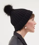 Gorro de lana negro con pompón de piel sintética en la parte superior.