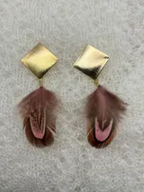 Par de aros colgantes con base redonda negra, detalles dorados y plumas negras.