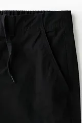 Pantalón cargo de lona de algodón con bolsillos laterales con solapa, bolsillos al bies y bolsillos traseros. Presenta pliegues en las rodillas y cierre con botón.