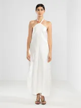 Vestido largo blanco de lino italiano con hilo metalizado y escote halter ajustable con cordón.