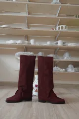 Bota de doble caña alta en gamuza negra, con punta cuadrada, taco cómodo y cierre lateral.