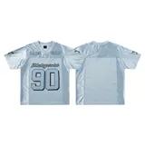Remera estilo jersey de fútbol o americana, color celeste claro, con paneles de tela satinada y malla microperforada. Presenta cuello en V con ribete blanco, el número "90" grande en el frente con borde negro, y texto en la parte superior que dice "BAEN MADE" y "Madcapsclub".