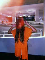 Poncho tipo blusa color naranja con vuelos laterales y cuerdita de hilo. Tejido de punto con hilado italiano de alta calidad. Confeccionado en rayón y viscosa con lurex.