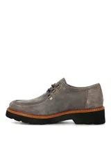 Zapatos de gamuza color gris de la marca Hush Puppies, modelo Renovo. Presentan diseño robusto con cordones gruesos, ojales metálicos, suela gruesa track y costuras pespunteadas en el borde.