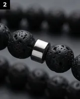 Collar de cuentas de piedra volcánica negra con detalles de eslabones cilíndricos de acero, diseño minimalista y masculino.