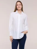 Camisa blanca de calce relajado, confeccionada en tejido suave y fluido, con cuello camisero, abotonadura frontal, mangas largas con puños anchos y ruedo curvo.