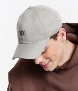 Gorra negra de sarga de algodón, con visera curva y bordado frontal con las letras "NY". Ajuste trasero con hebilla metálica.