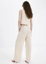 Pantalón largo de tiro medio, color beige, con diseño recto, trabillas para cinto y bolsillos laterales.