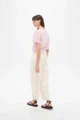 Pantalón jean slouchy de tiro alto, color natural, con detalle de bordadoado en el borde inferior.