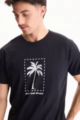 Remera negra de manga corta y corte regular fit, confeccionada en algodón, con estampa frontal que presenta una palmera dentro de un rectángulo punteado y la inscripción 'palm tree dream'.