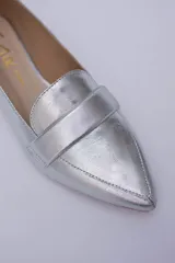 Mocasines negros de cuero con punta fina y detalle de antifaz.