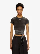 Top ajustado de manga corta, color negro con efecto lavado o acid wash, y un pequeño logo bordado en el pecho. Incluye una banda larga de tela que se anuda alrededor de la cintura a modo de fajín o cinturón.