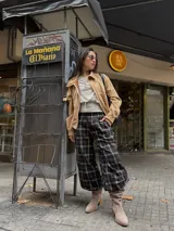 Pantalón de corte holgado estilo barrel con estampado de cuadrillé en tonos oscuros. Presenta cintura elástica y diseño cómodo, ideal para un look urbano.