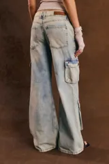 Pantalón cargo de denim celeste con efecto acid wash, corte ancho y múltiples bolsillos con solapa en los laterales y a la altura de las pantorrillas.