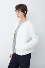 Campera acolchada tipo puffer en color beige, con diseño sin cuello y cierre frontal con botones a presión.